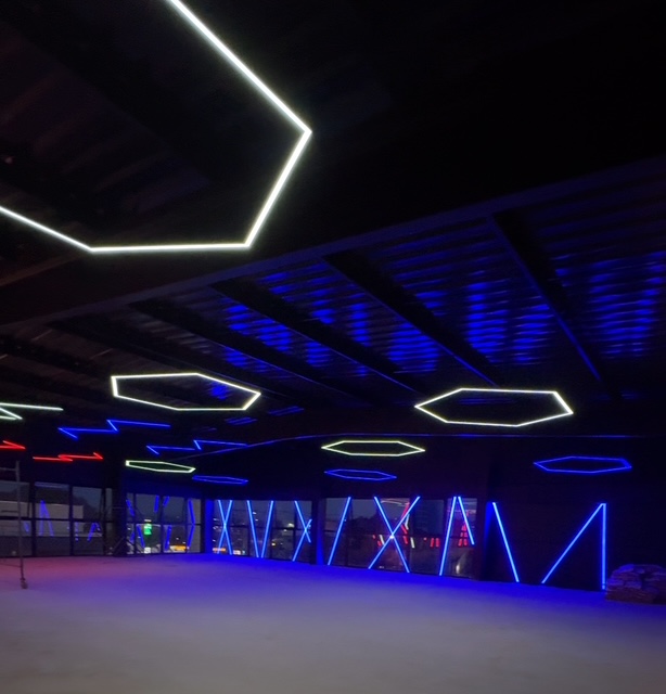 Studio de dança com linhas de LED no teto e nas paredes